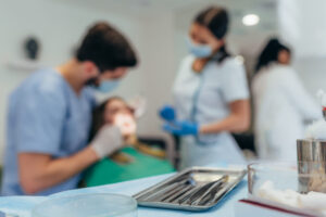 dois profissionais de odontologia atendendo uma paciente na clinica odontológica